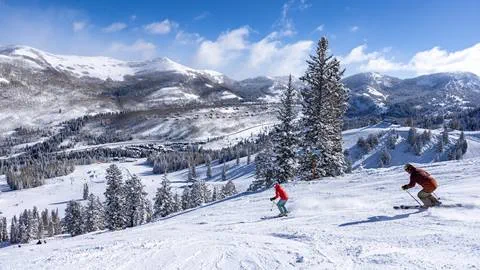 Two people skiing down a run at Solitude Mountain Resort