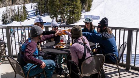 Friends enjoying après beers and appetizers on the rooftop deck of Argenta Pub at Solitude Mountain Resort