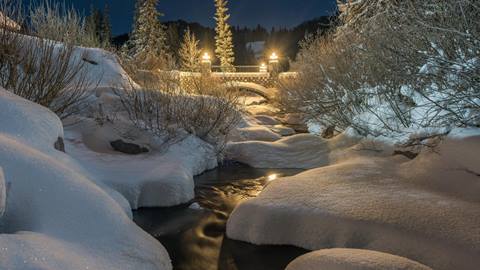 Nighttime view of Big Cottonwood Creek under a footbridge at Solitude Mountain Resort